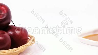 一堆红苹果和一堆红苹果放在白色盘子上，白色背景上隔离蜂蜜